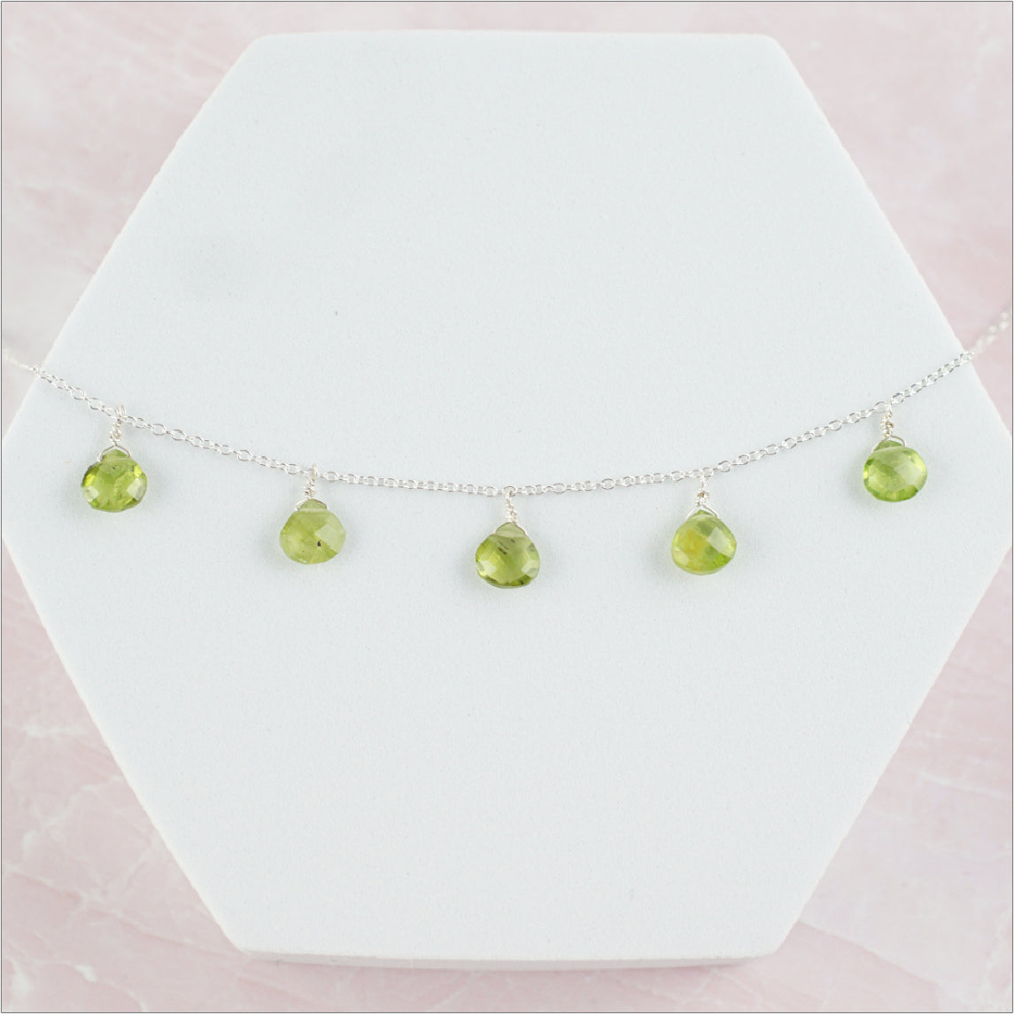 Peridot Necklace Display on Pink Background