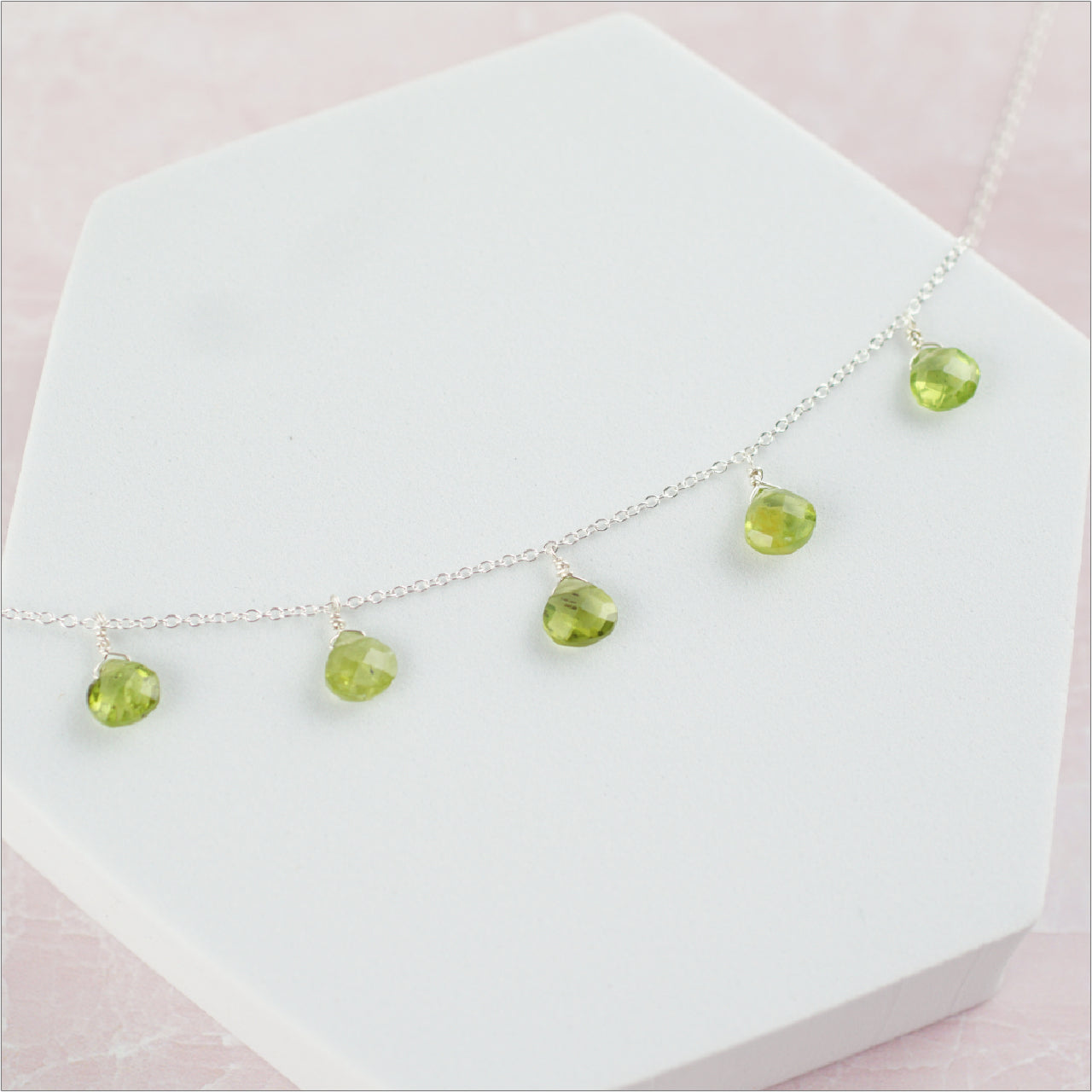 Peridot Necklace Display on Pink Background